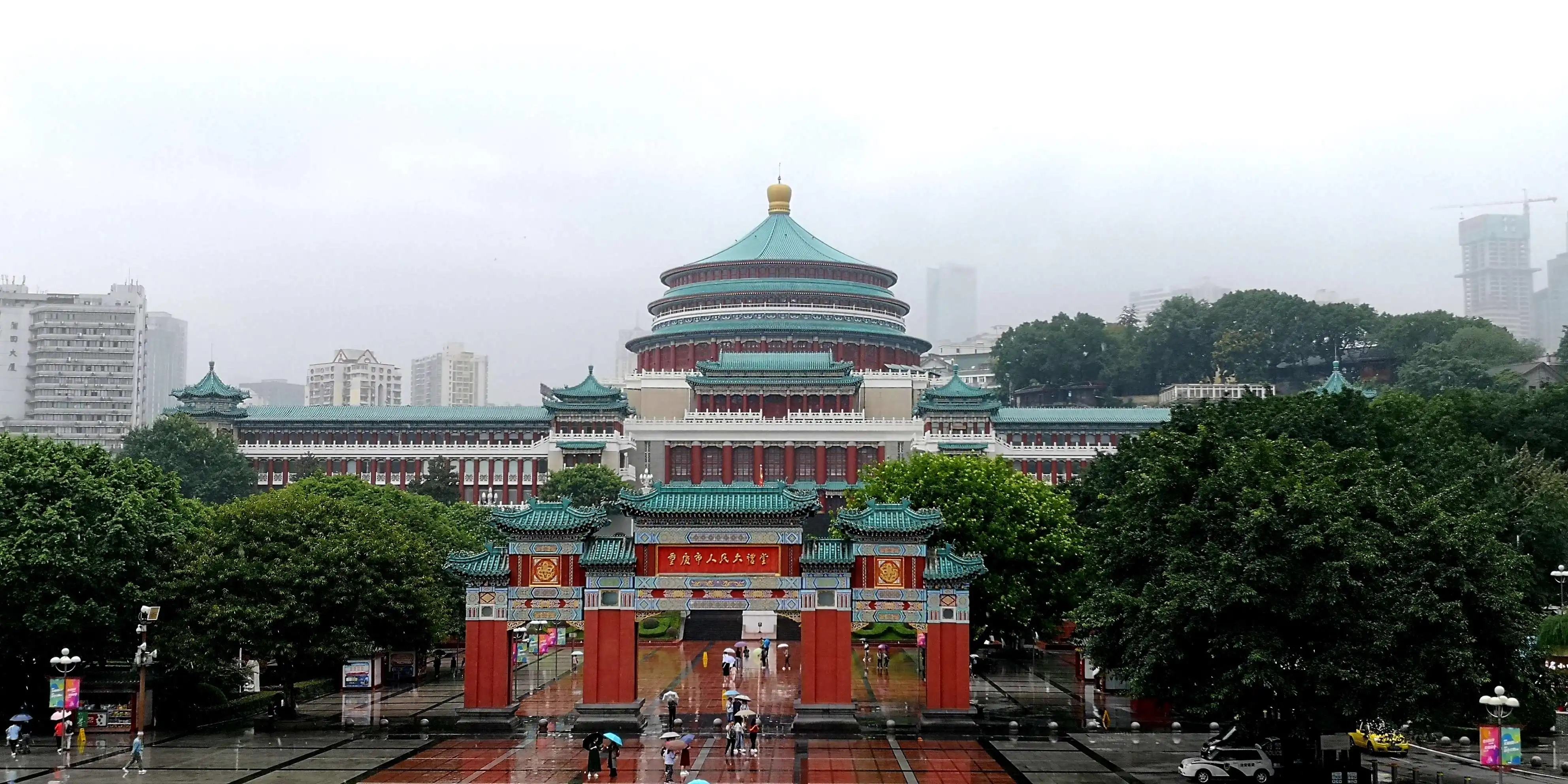 重庆动物园熊猫馆，大熊猫悠闲地坐在竹林中，游客围观观赏，环境优美